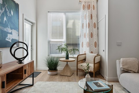 a living room with a couch and a chair and a window