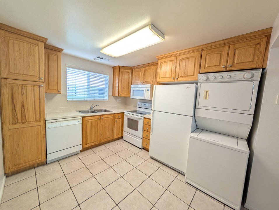 A kitchen with wooden cabinets and white appliances.