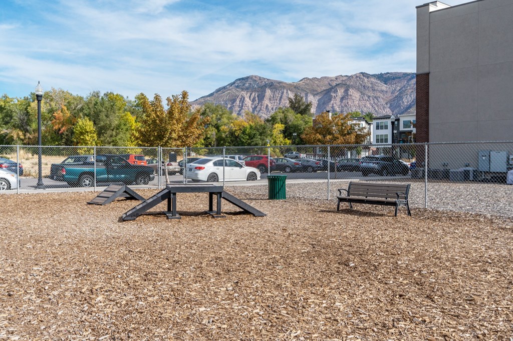 a picnic area with benches and a picnic table in front of a building with mountainsat The View on 20th, Ogden, Utah