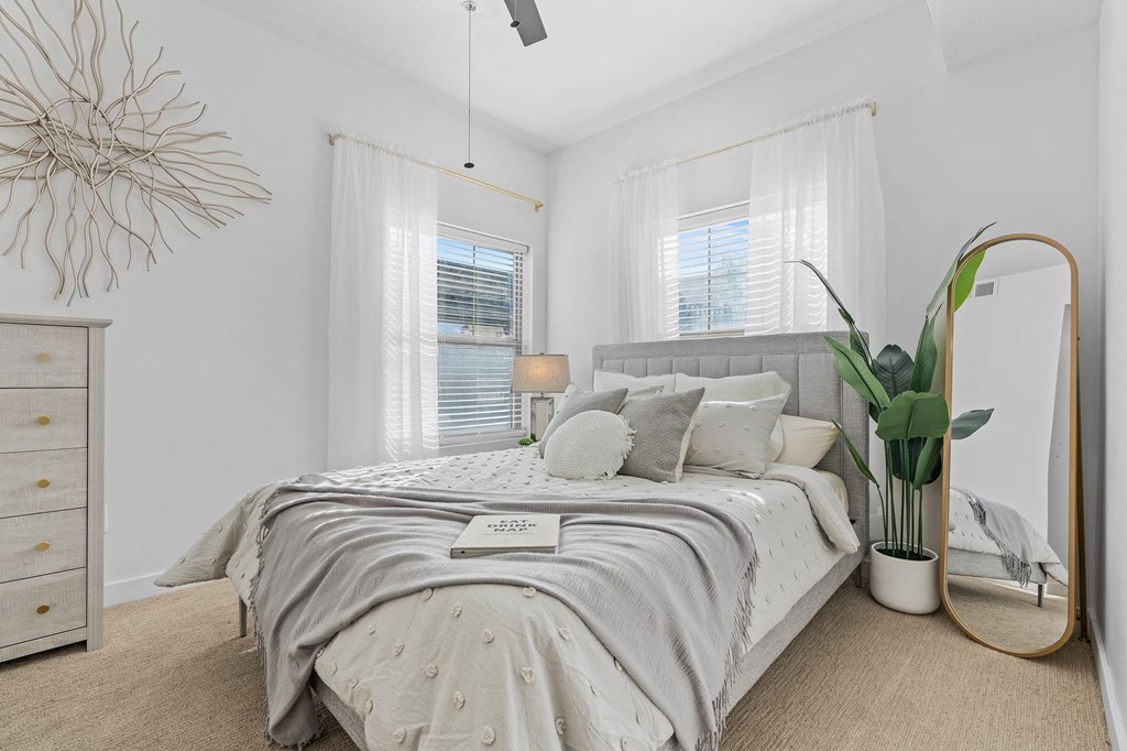 a white bedroom with a bed and a mirrorat The View on 20th, Ogden