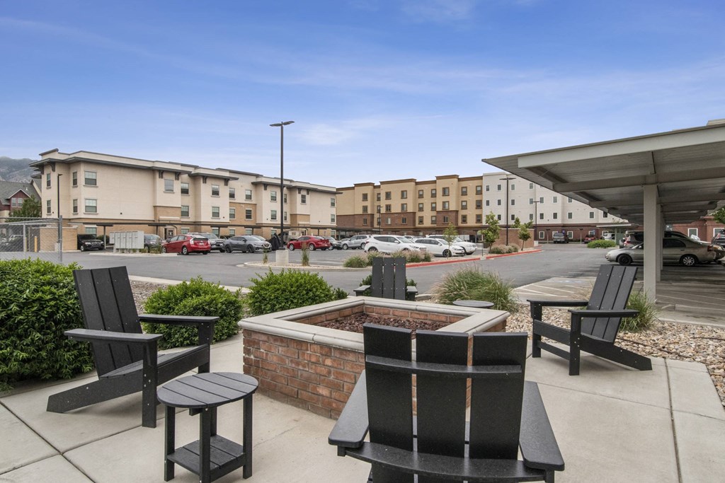 a patio with chairs and a firepit at the whispering winds apartments in pearland, tx at The View on 20th, Ogden, Utah