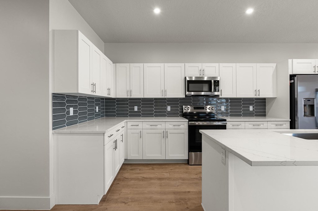 A kitchen with white cabinets and a marble countertop. at The Vue At Desert Color, Utah