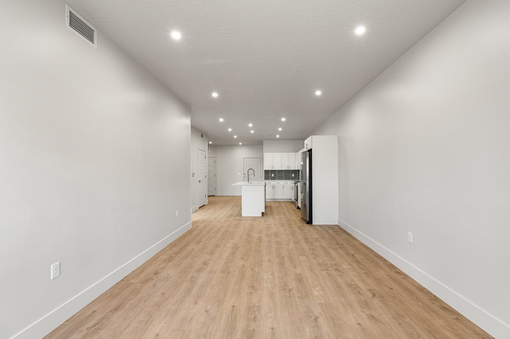 A long hallway with a white wall and wooden floor. at The Vue At Desert Color, St. George, 84790