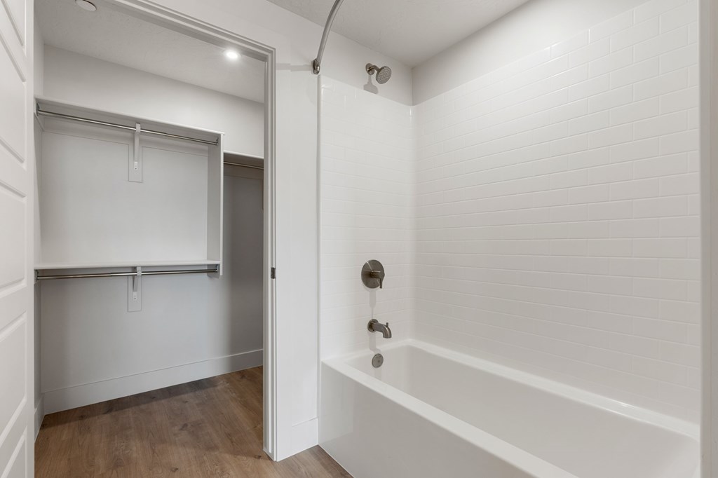 A white bathroom with a white tub and a white door. at The Vue At Desert Color, St. George, Utah