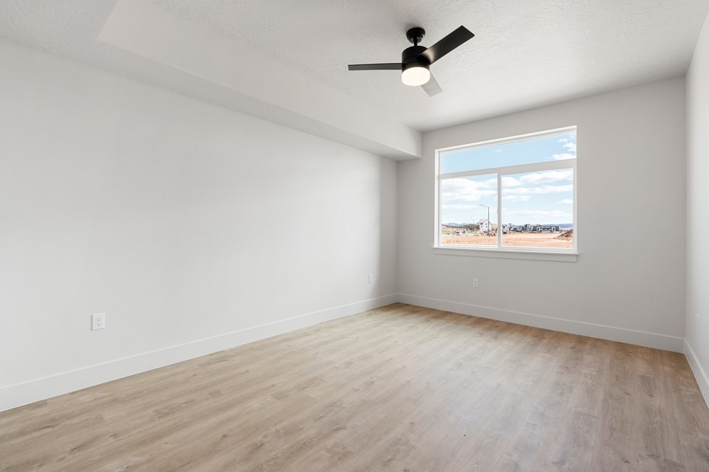 Empty room with a ceiling fan and a window showing a beach view. at The Vue At Desert Color, St. George, UT, 84790