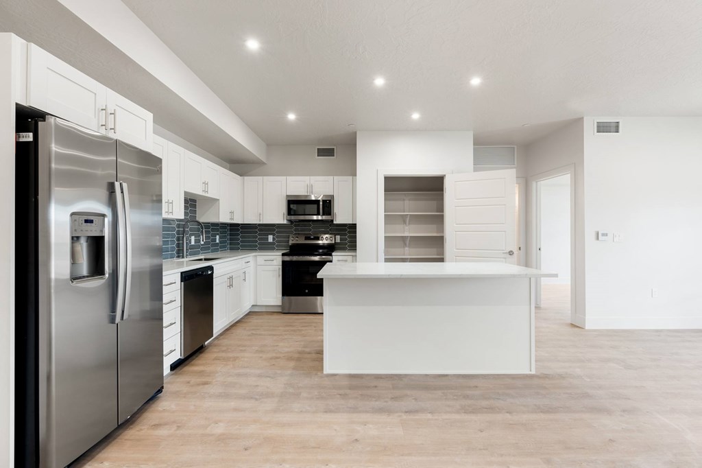 A modern kitchen with stainless steel appliances and white cabinetry. at The Vue At Desert Color, St. George, UT, 84790