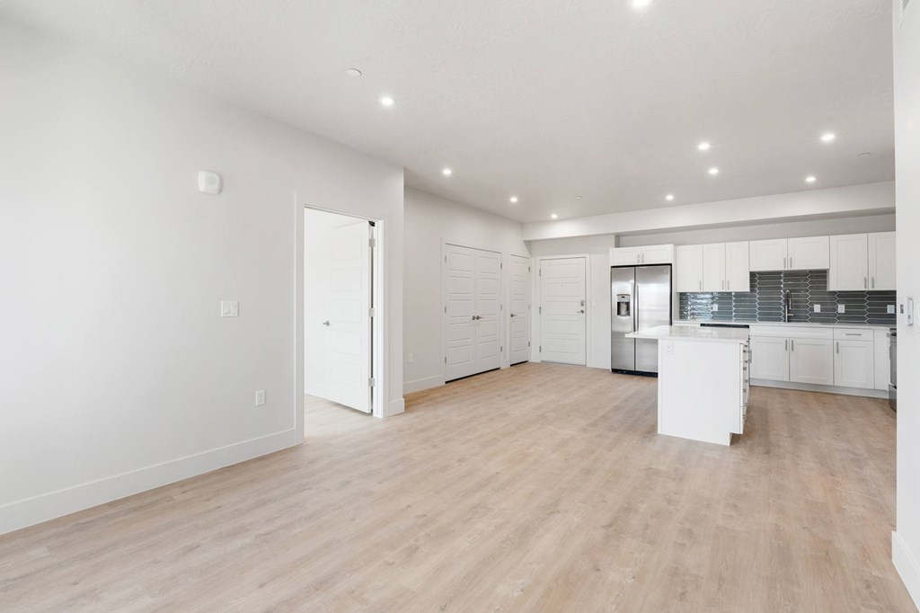 A spacious kitchen with white cabinets and a wooden floor. at The Vue At Desert Color, St. George, 84790