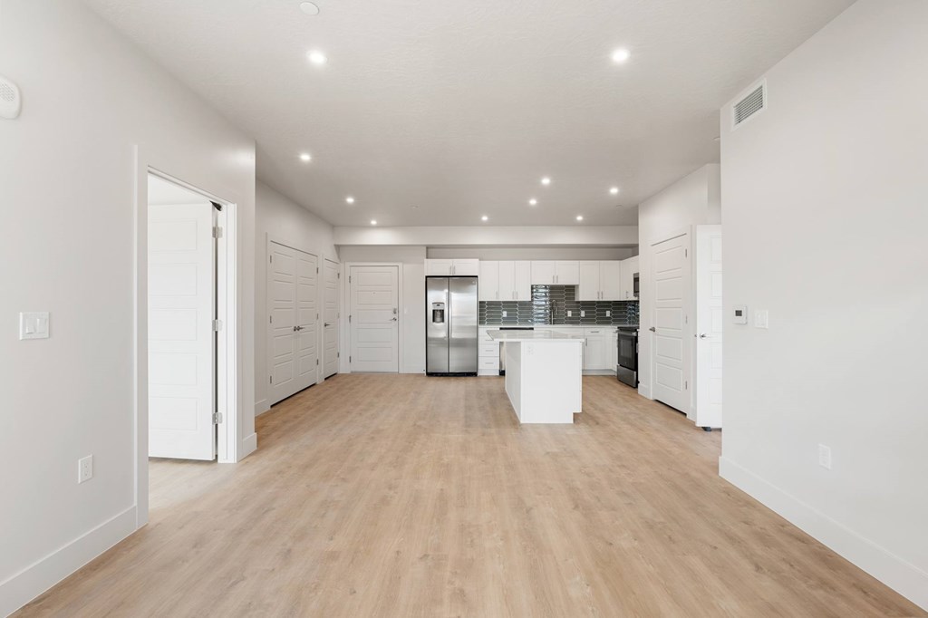 A spacious kitchen with white cabinets and a wooden floor. at The Vue At Desert Color, St. George, 84790