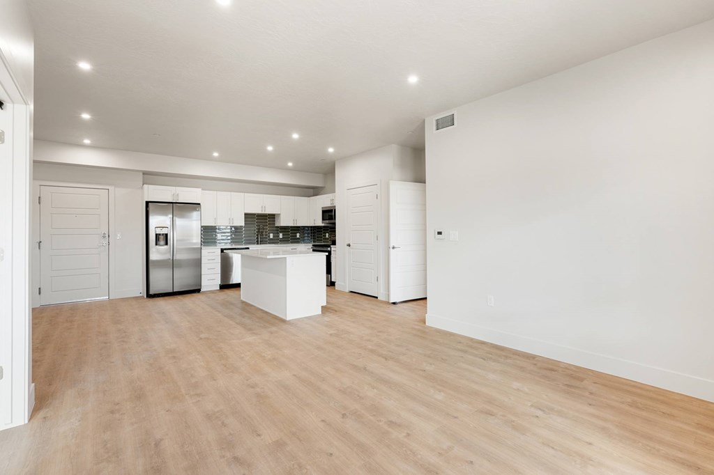 A kitchen with white cabinets and a wooden floor. at The Vue At Desert Color, St. George, 84790