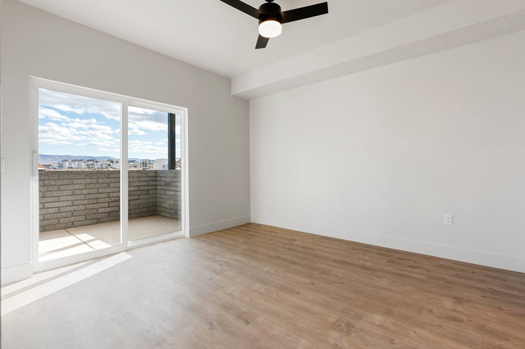A room with a ceiling fan and a view of the outside through a window. at The Vue At Desert Color, St. George, Utah