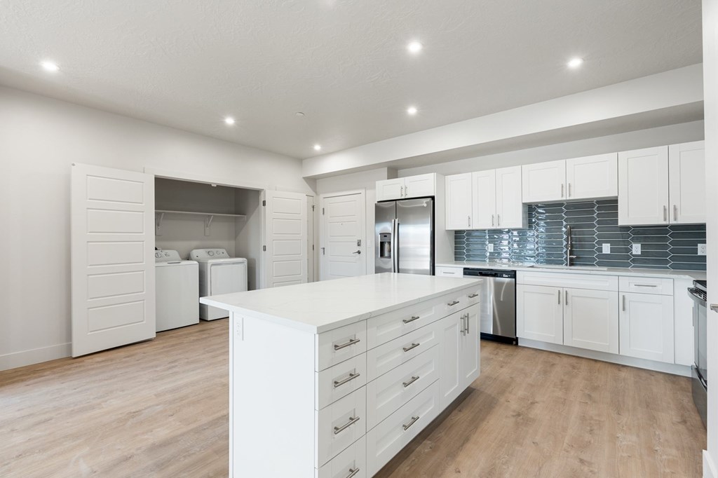 A modern kitchen with white cabinets and a central island. at The Vue At Desert Color, St. George, UT, 84790