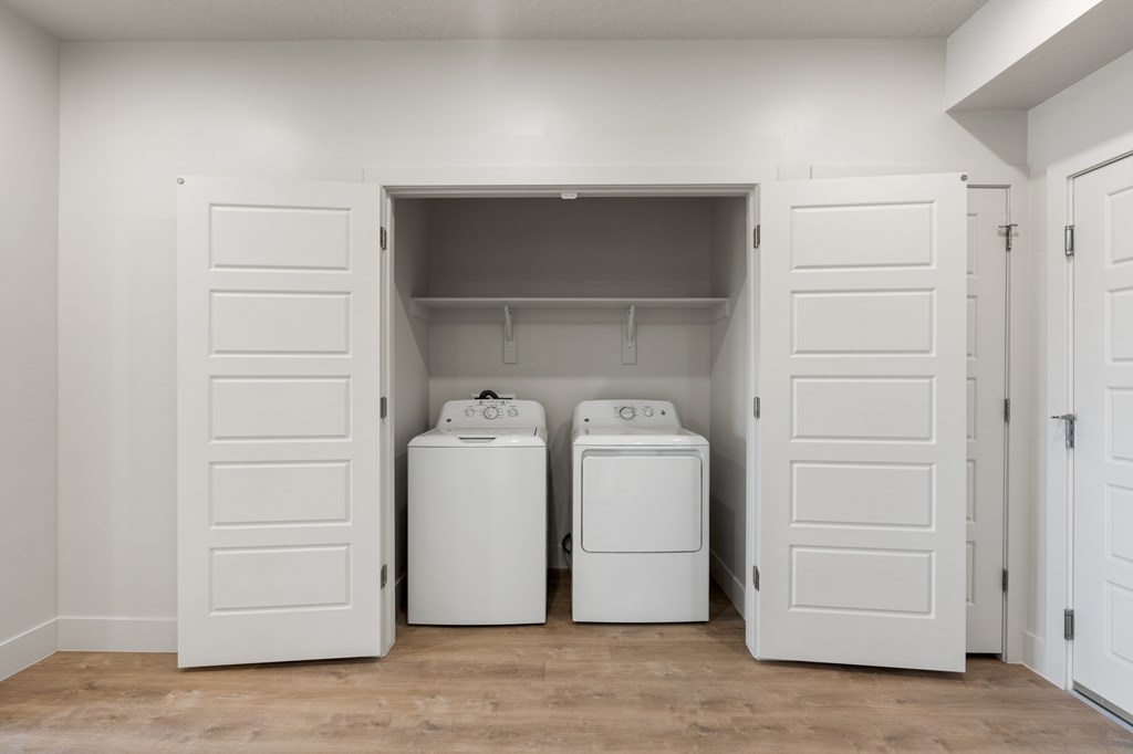 A laundry room with two washing machines and a dryer. at The Vue At Desert Color, St. George, Utah
