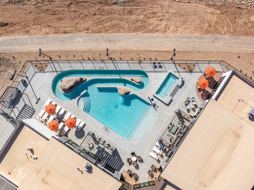A large outdoor swimming pool with a slide and sun loungers. at The Vue At Desert Color, St. George, Utah