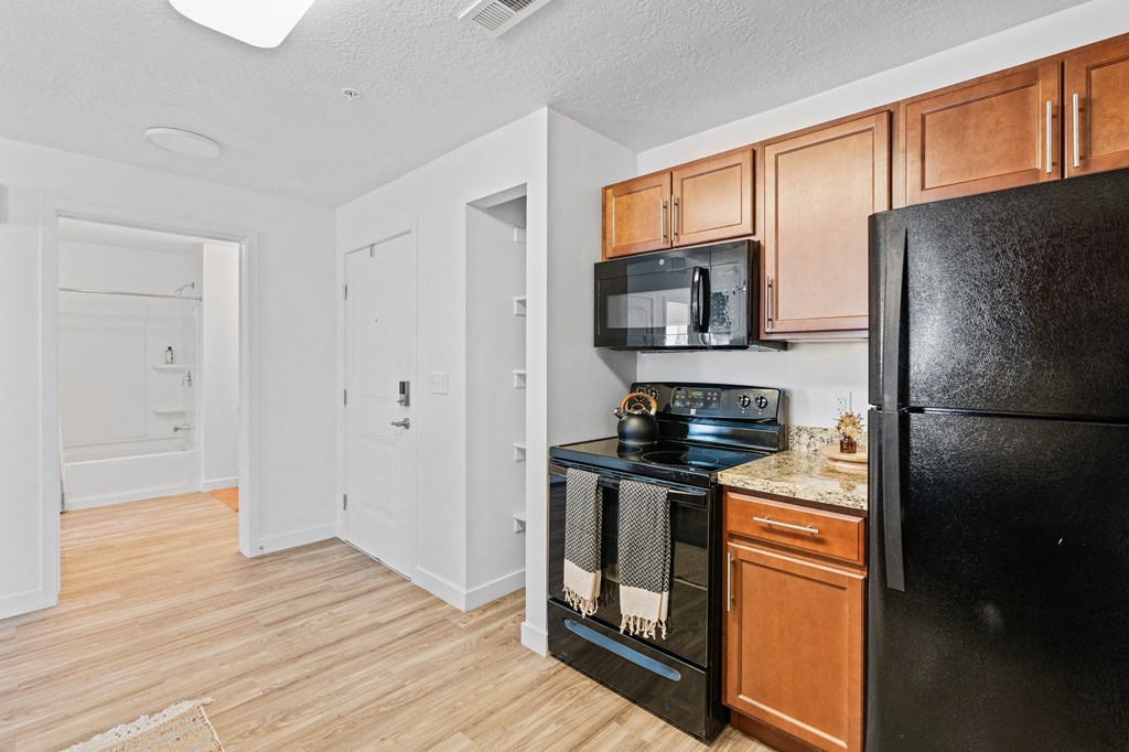 a kitchen with black appliances and wooden cabinetsat The View on 20th, Utah
