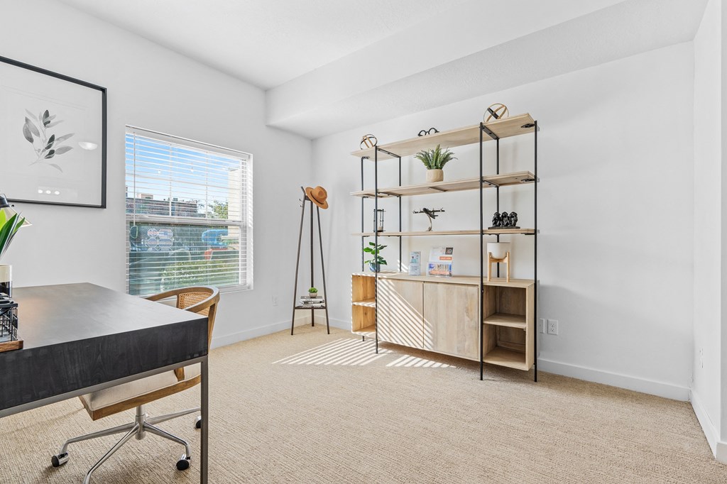 an office with a desk and a window and a shelf with plantsat The View on 20th, Ogden, 84401