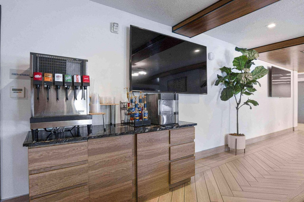 a large flat screen tv hangs above a kitchen countertop at The Flats at Riverwoods, Provo, UT, 84604