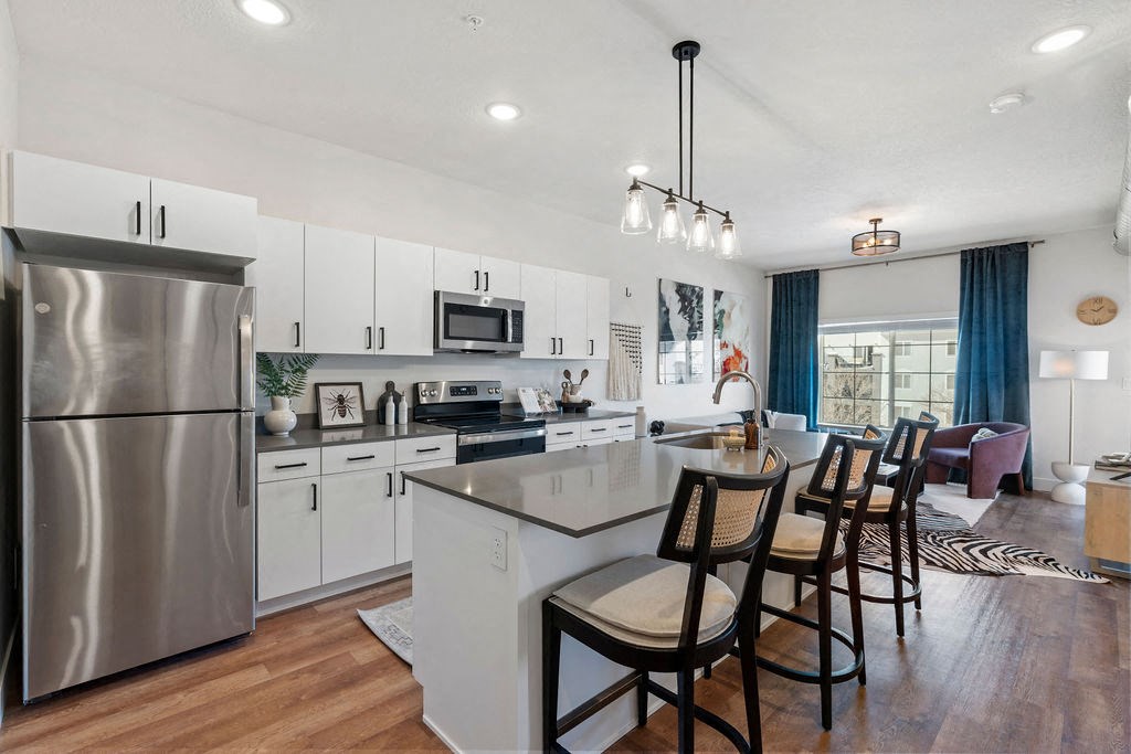 an open kitchen and dining area with a stainless steel refrigerator at The Revival, Salt Lake City