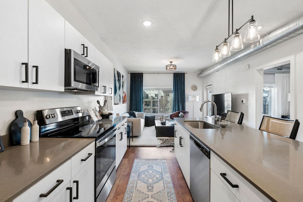 an open kitchen with counters and appliances and a living room at The Revival, Salt Lake City, 84101