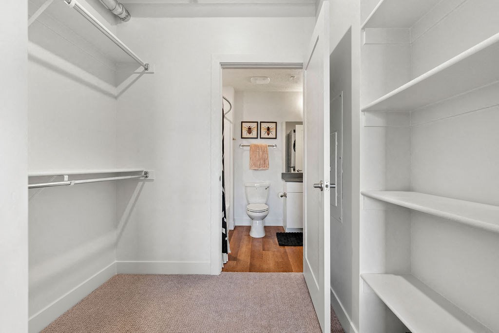 a white bathroom with a toilet and a closet at The Revival, Salt Lake City, 84101