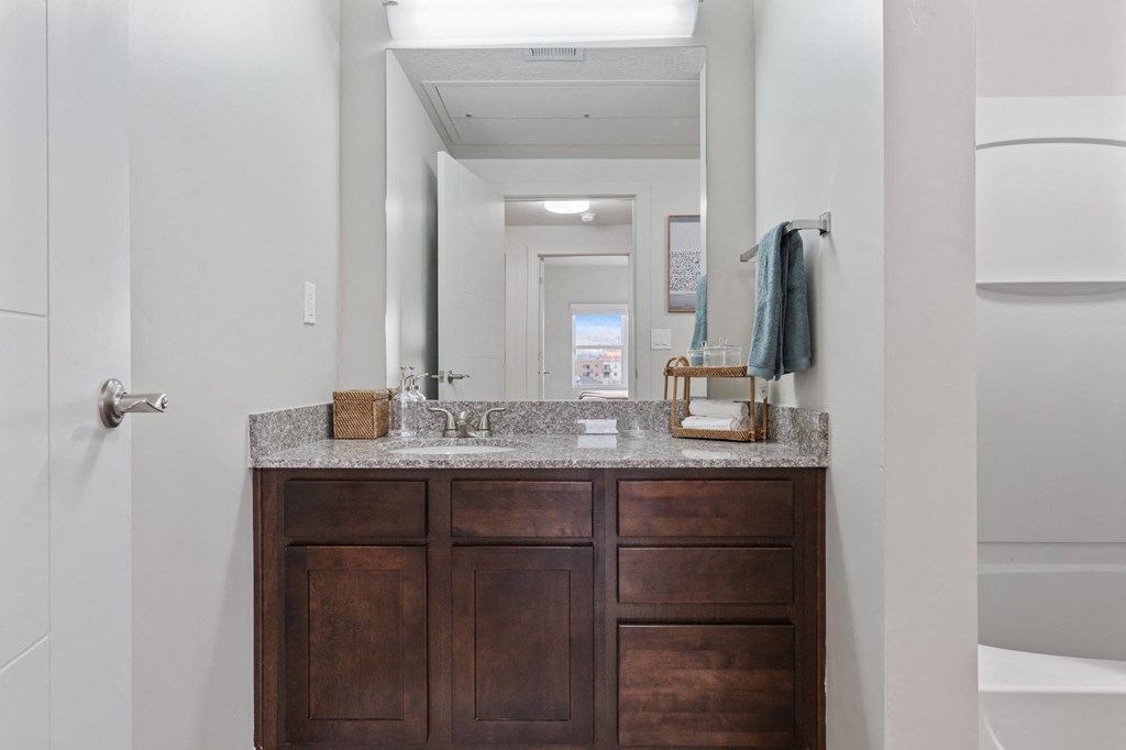 A bathroom with a wooden vanity and a mirror above it at Wilmington Flats Apartments, Salt Lake City, UT