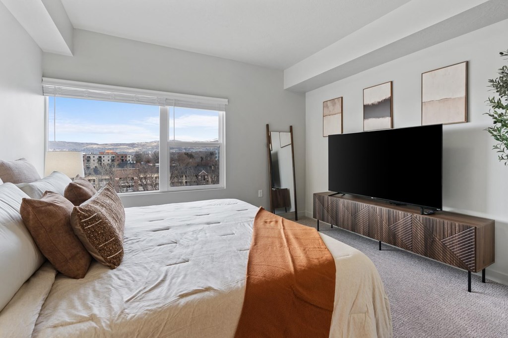 A bedroom with a large bed and a television at Wilmington Flats Apartments, Utah