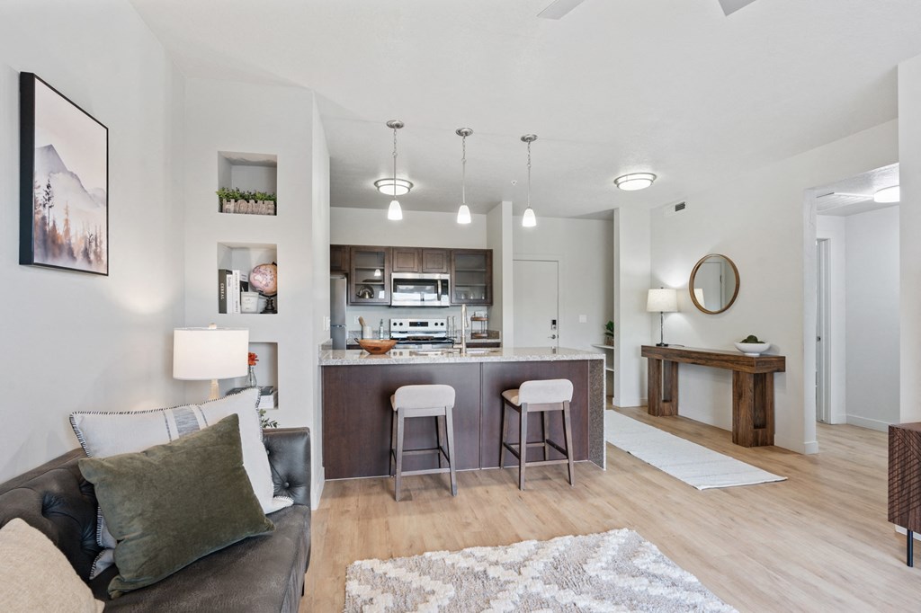 A modern living room with a couch, bar stools, and a fireplace at Wilmington Flats Apartments, Salt Lake City, UT, 84106