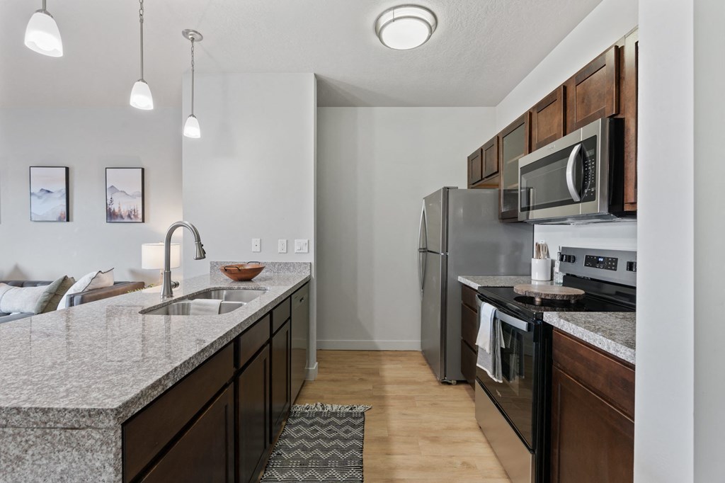A kitchen with a granite countertop and stainless steel appliances at Wilmington Flats Apartments, Salt Lake City, 84106