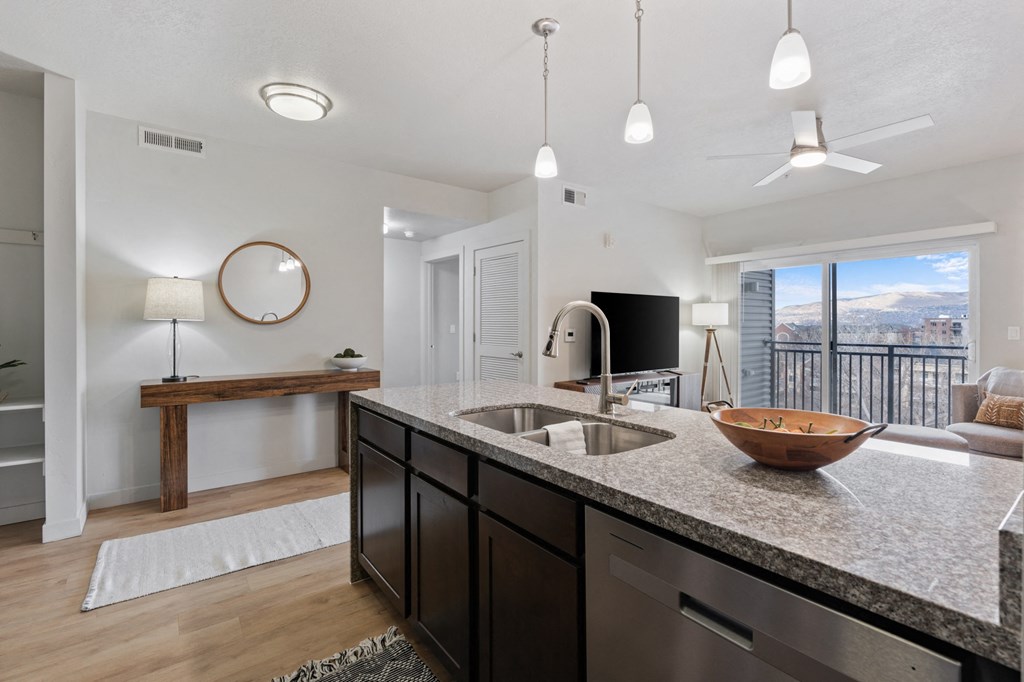 A modern kitchen with a large island and a view of the mountains at Wilmington Flats Apartments, Utah, 84106