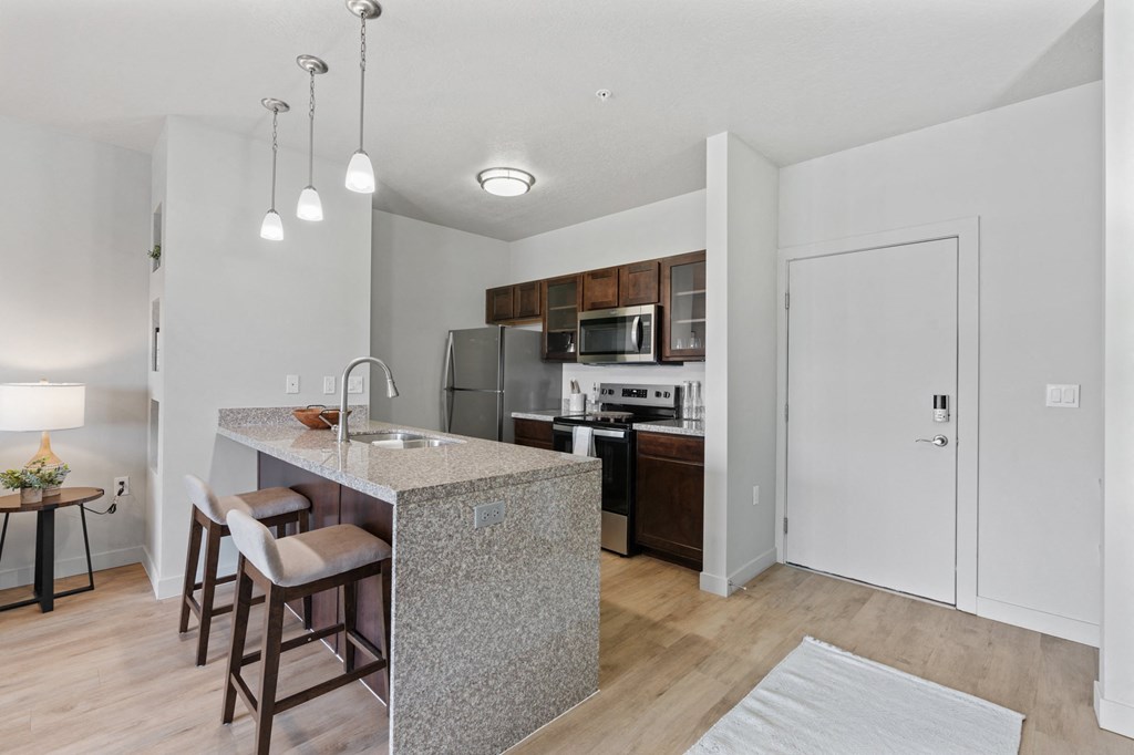 A kitchen with a bar area and a refrigerator at Wilmington Flats Apartments, Salt Lake City, UT, 84106