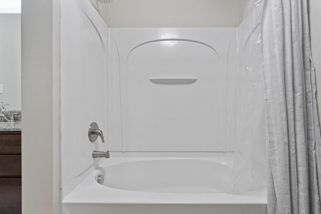 A white bathroom with a tub and a shower at Wilmington Flats Apartments, Utah