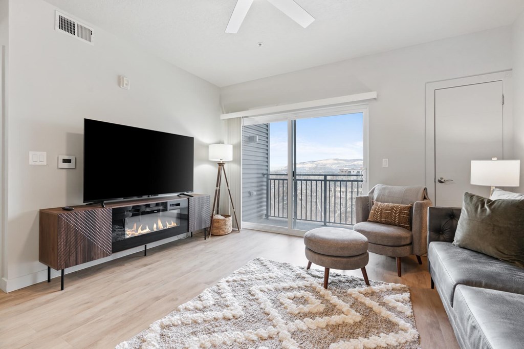 A modern living room with a flat screen TV and a fireplace at Wilmington Flats Apartments, Salt Lake City