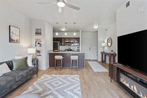 A modern living room with a grey couch and a fireplace.