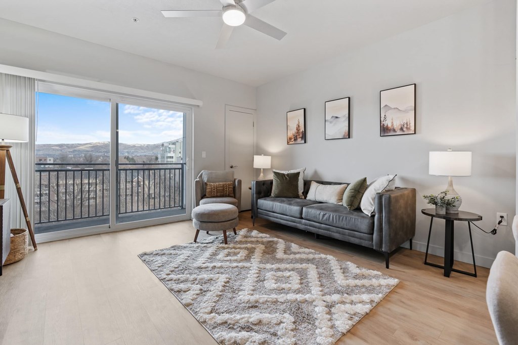 A living room with a grey couch, a rug, and pictures on the wall at Wilmington Flats Apartments, Salt Lake City, UT