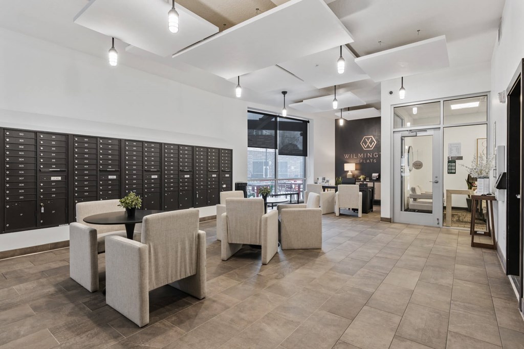 A modern waiting room with beige chairs and a black board on the wall at Wilmington Flats Apartments, Salt Lake City, Utah