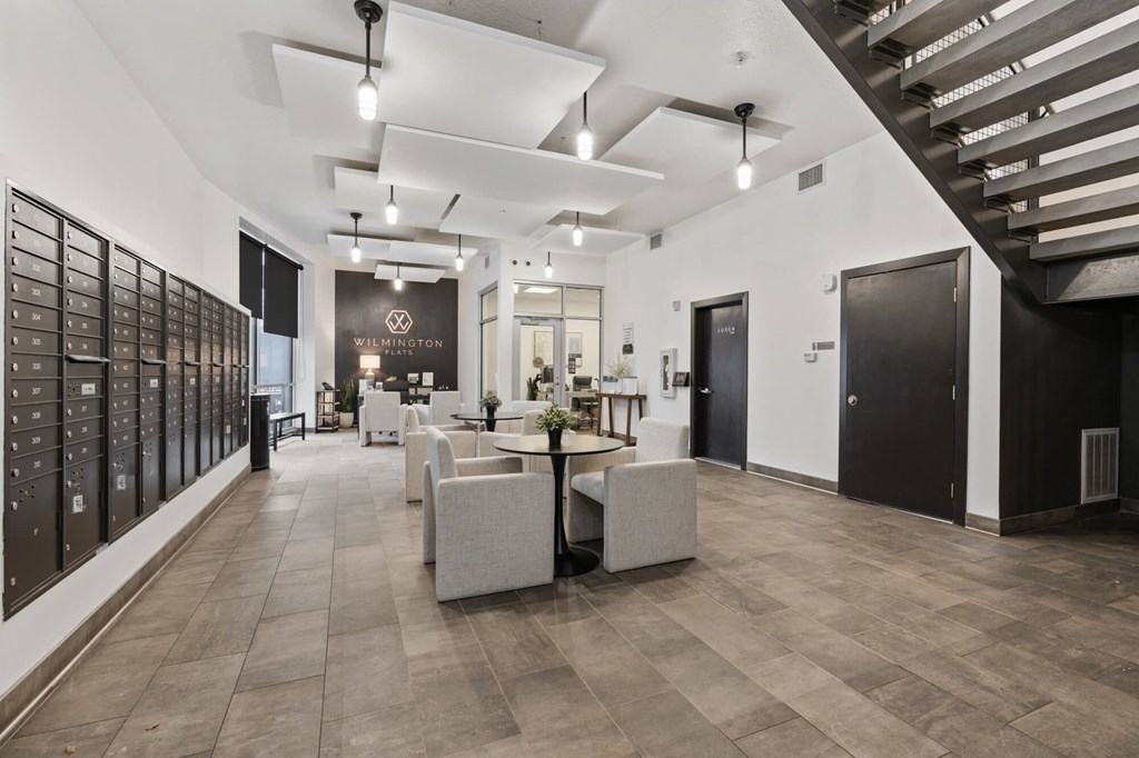 A spacious interior with a staircase on the right and a long wall of mailboxes on the left at Wilmington Flats Apartments, Salt Lake City, Utah
