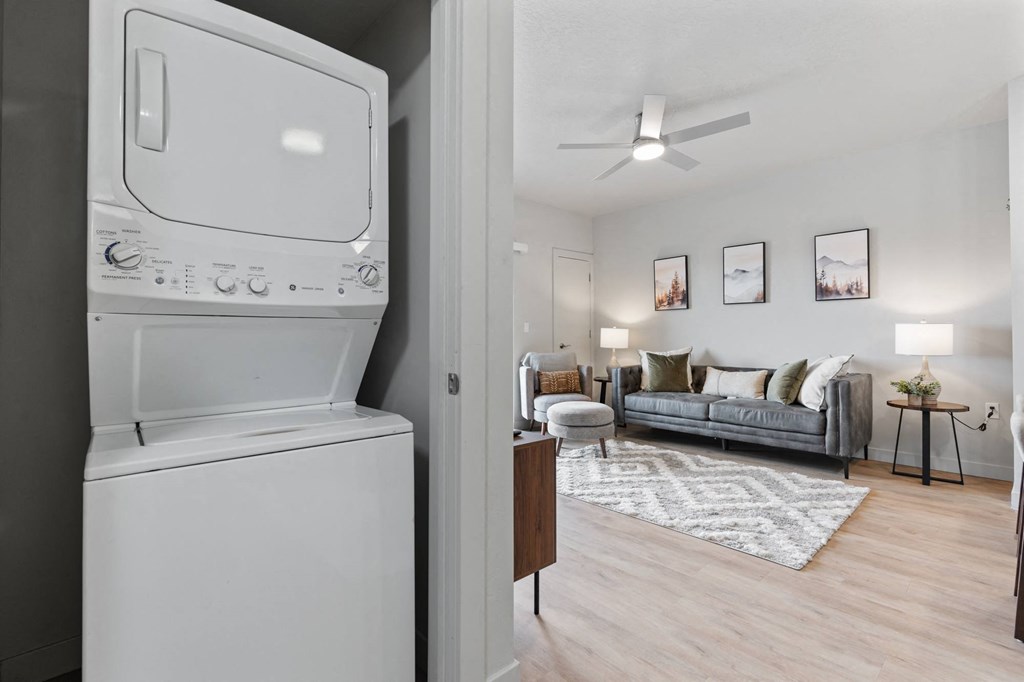 A white washing machine is in a laundry room at Wilmington Flats Apartments, Utah