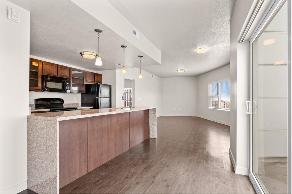 a kitchen and living room with hardwood floors and a sliding glass door at Wilmington Flats Apartments, Salt Lake City, UT