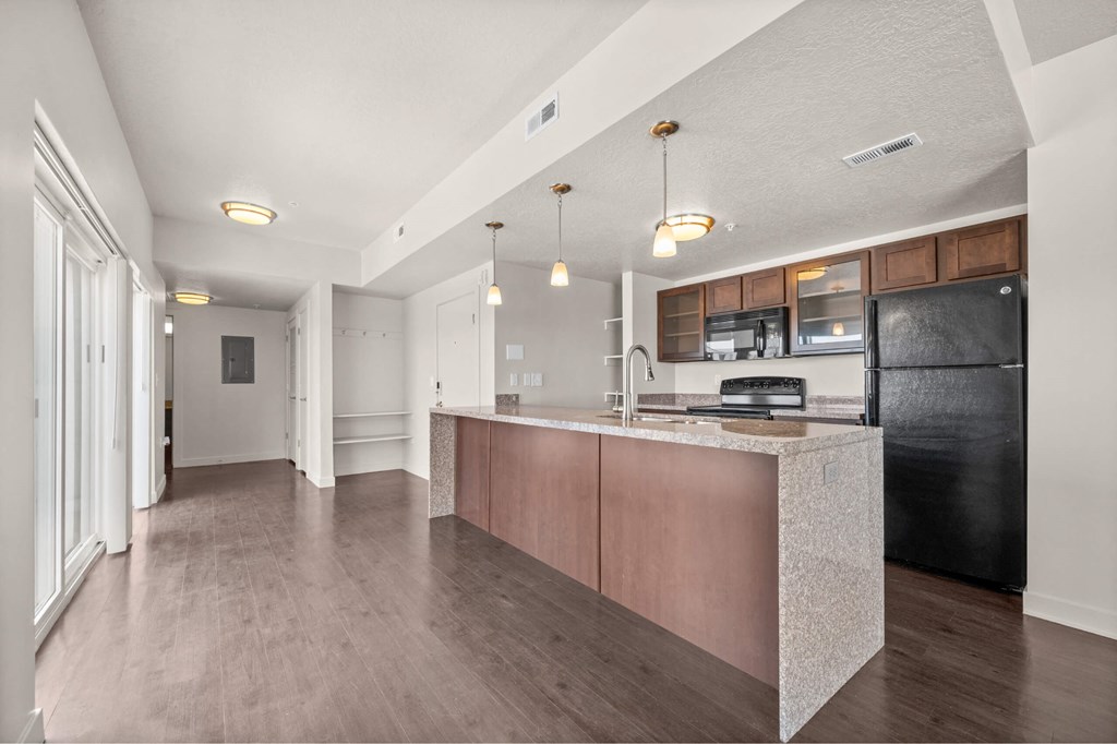 a kitchen with an island and a black refrigerator at Wilmington Flats Apartments, Salt Lake City, Utah