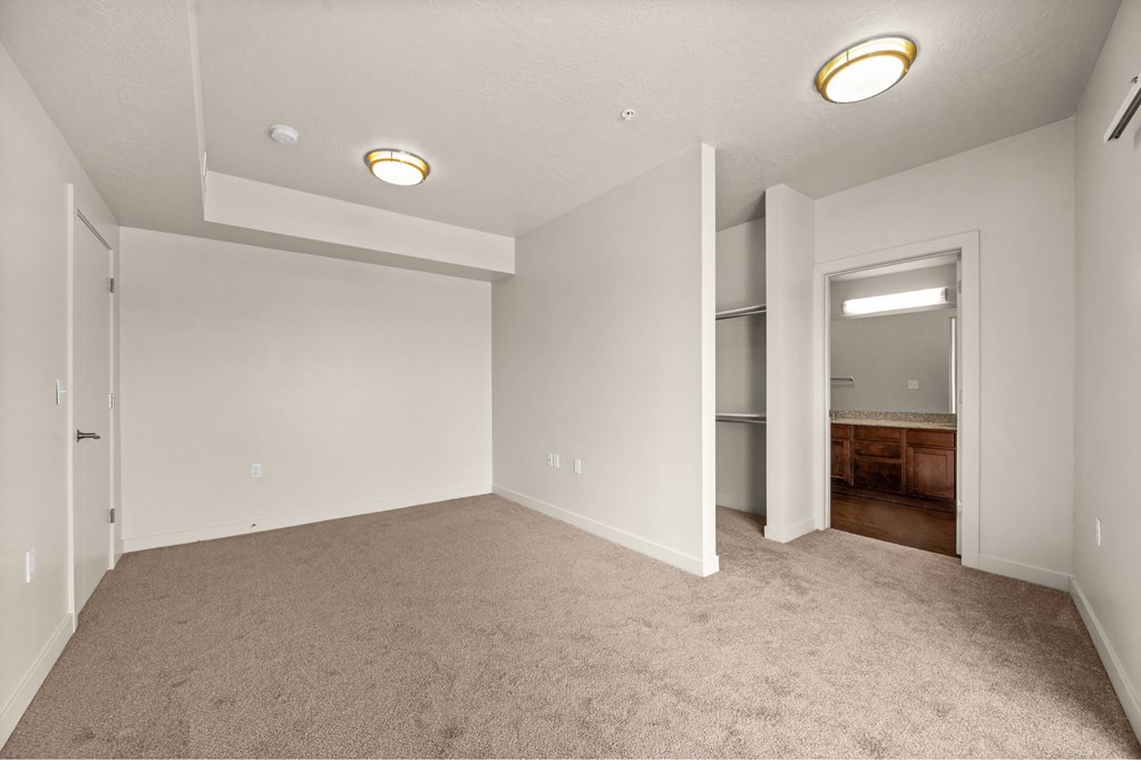 a bedroom with gray carpet and white walls at Wilmington Flats Apartments, Utah