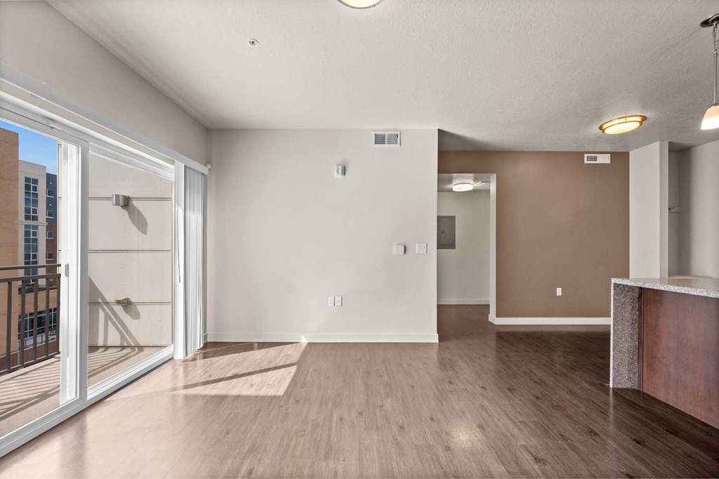 a living room with hardwood floors and a glass sliding door to a balcony at Wilmington Flats Apartments, Salt Lake City, Utah