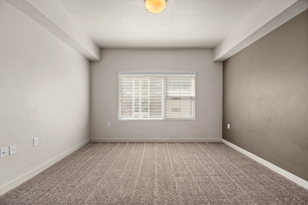 an empty room with a large window and a carpeted floor at Wilmington Flats Apartments, Utah