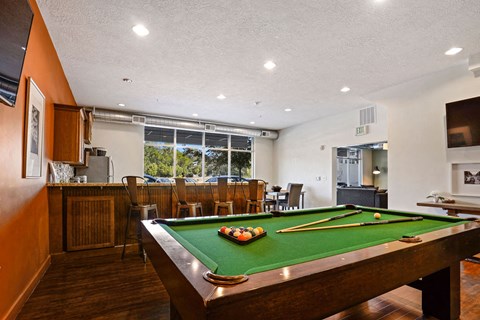 a game room with a pool table and a bar