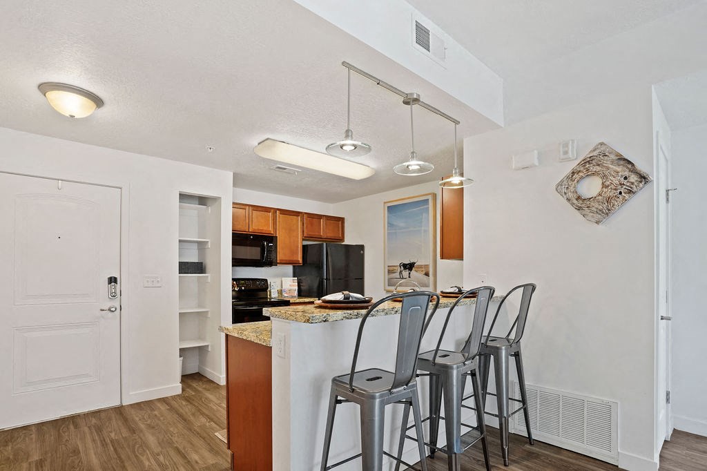 a kitchen with an island and three stools at the counter at The View on 20th, Ogden, Utah