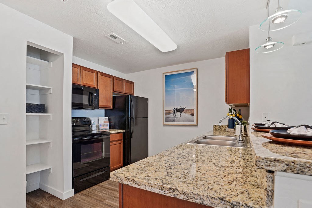 a kitchen with granite countertops and black appliances at The View on 20th, Ogden, UT, 84401