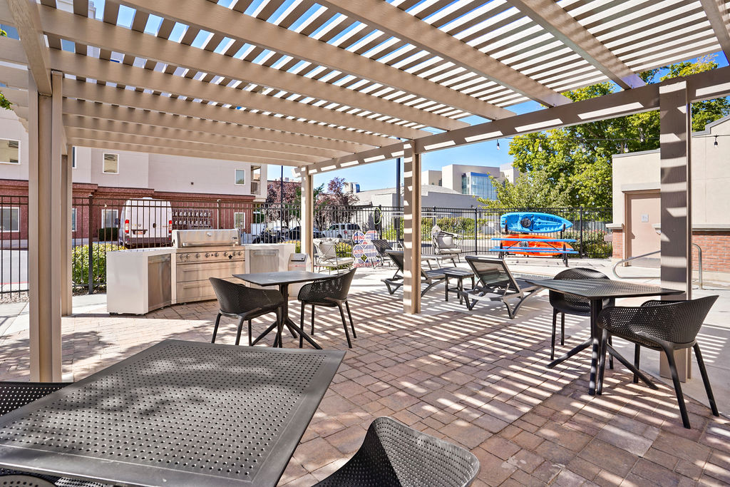 a pergola with tables and chairs on a brick patio at The View on 20th, Ogden, UT