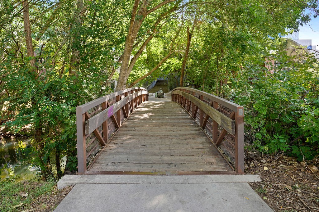a wooden bridge over a river with trees on both sides at Wilmington Flats Apartments, Utah, 84106