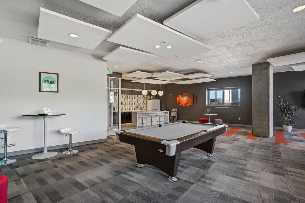 a games room with a pool table and bar