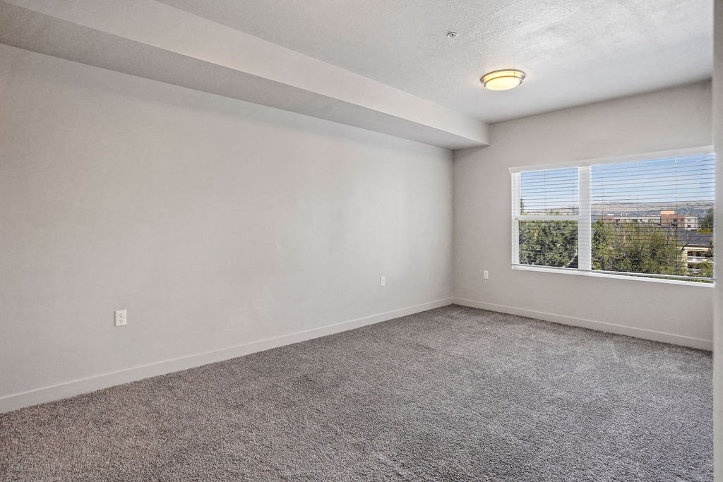 an empty bedroom with a large window at Wilmington Flats Apartments, Utah, 84106