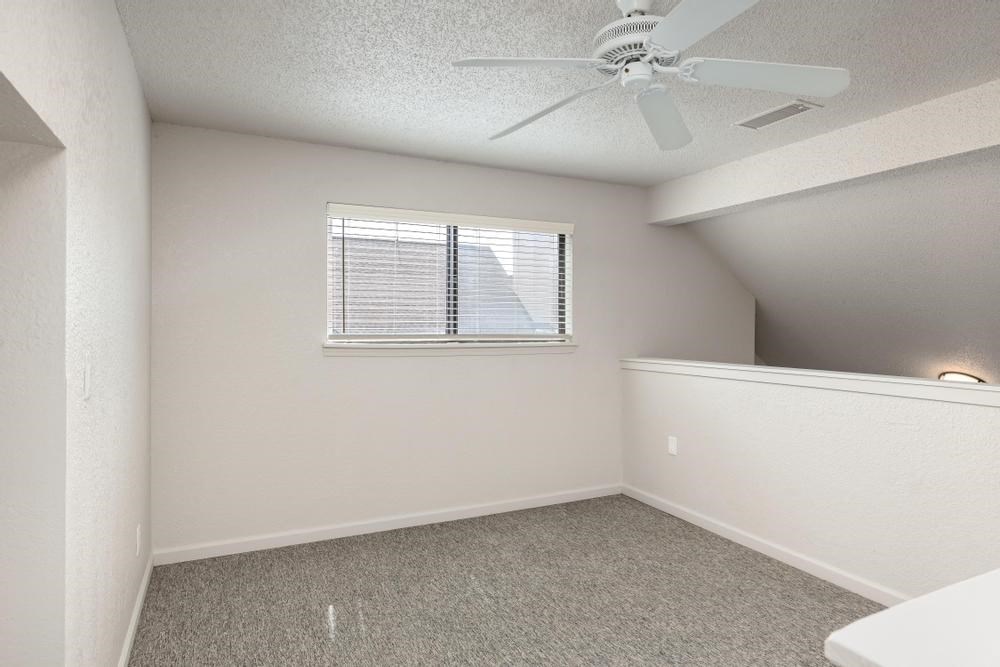 a bedroom with a ceiling fan and a window
