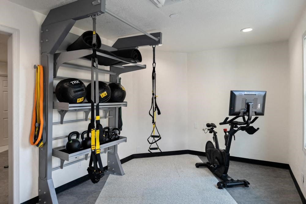 a home gym with a treadmill and weights